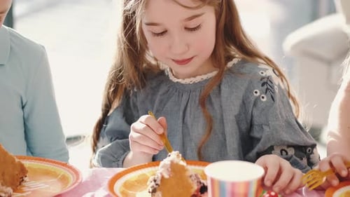 Group of Children Eating at Birthday Party in Funny Decorations