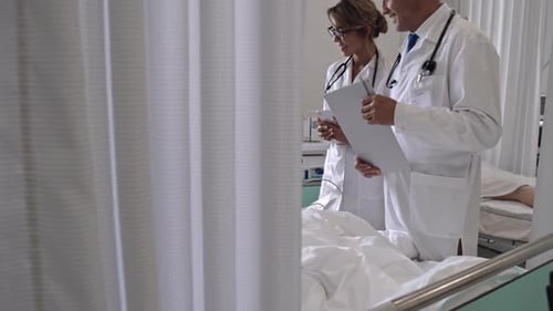 Doctors Talking to Senior Patient in Hospital Room