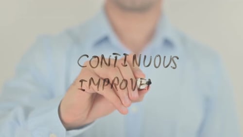 Continuous Improvement, Man Writing on Transparent Screen