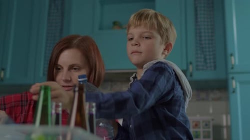 Child Helps Mother With Recycling at Home