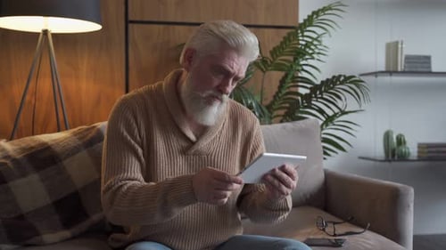 Senior Man Using Tablet Device in Cozy Home