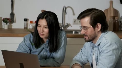 Close up A young woman and man are working in their kitchen background. Using a Tablet