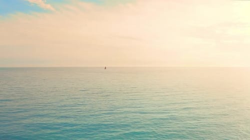 Calm Ocean with Sailboat at Sunset