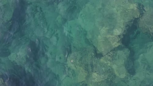 Close Up of Transparent Turquoise Sea Water and Stones at the Bottom