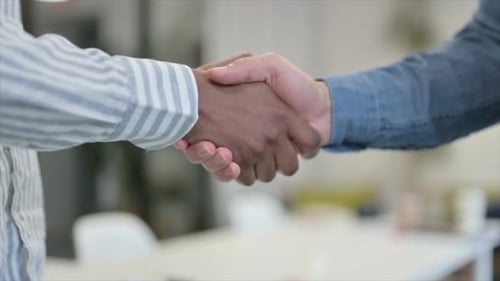 Close Up of African Man Shaking Hands with White Man