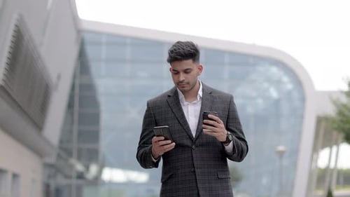 Businessman On Park Bench With Coffee Using Mobile Phone
