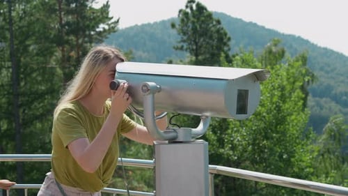Woman Tourist Looks Through Tower Viewer on Observation Deck