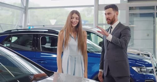 Car Salesperson Explaining Features to Woman in Dealership