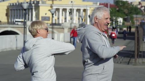 Active Man and Woman Exercising in City