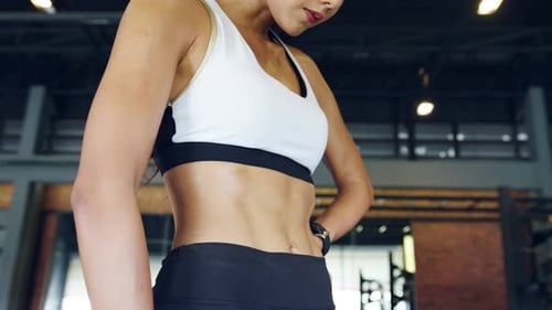 Athletic Woman with Six Pack Abs at Gym