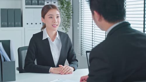 Asian beautiful woman applicant give resume and talk with hr manager for job interview in office.