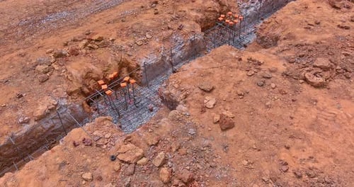 Se está preparando un sitio de construcción con una zanja excavada debajo de una base de concreto para una nueva casa