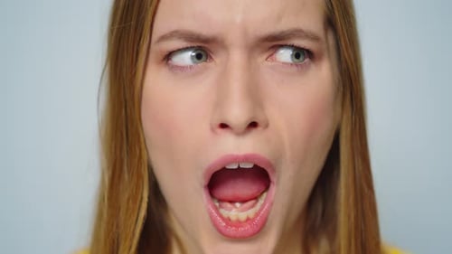 Closeup Mulher alegre fazendo caretas engraçadas em fundo cinza no estúdio
