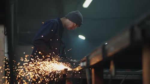A Man in Protective Glasses Works with Metal Grinding Polishing and Stripping Steel Metal Structures