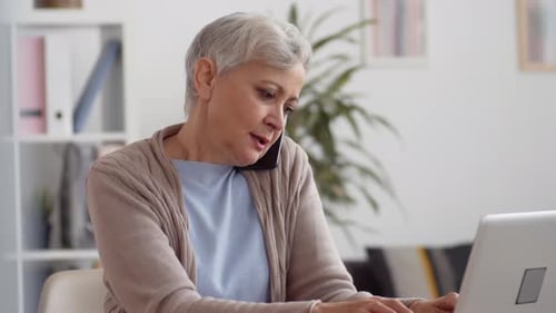 Elderly Female Office Worker Having Phone Call