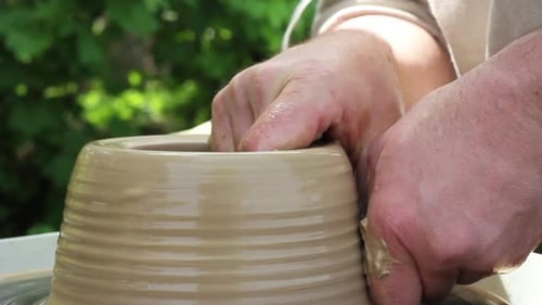 a Male Potter of Caucasian Ethnicity in a Work Shirt Makes a Bowl of Clay