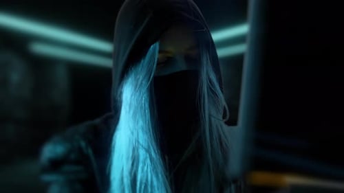 Junge anonyme Hacker-Frau mit Maske. Dieb stiehlt Daten vom Computer oder Hackersystem