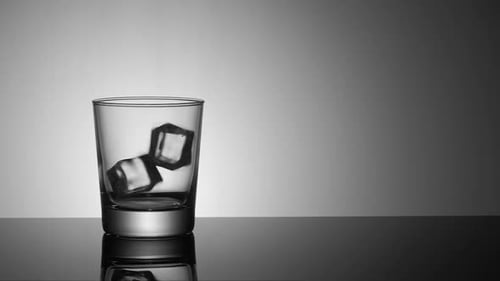 Ice Cubes Falling into a Glass in Studio