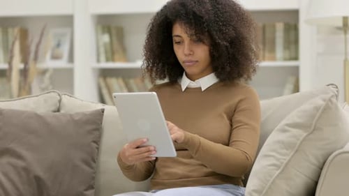 Woman Using Tablet on Couch at Home