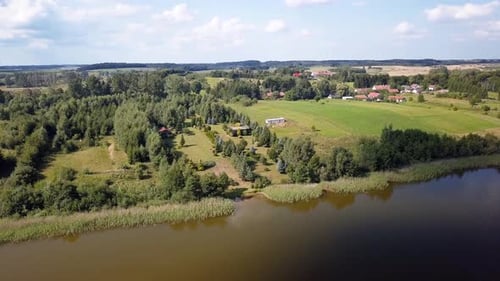 Aerial shot of a secluded lake, surrounded by fields and farms. Relaxing scenery. Beautiful colors.
