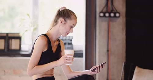 Athletic Woman Using Mobile Phone At Gym