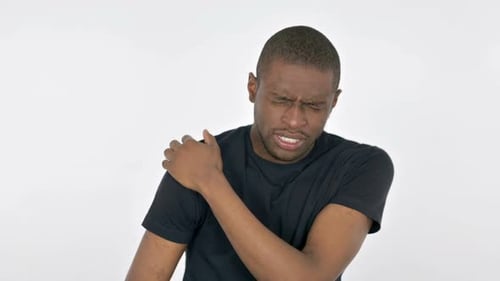 Man Holding Shoulder in Pain Against White Backdrop
