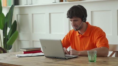 Smiling Male Call Center Operator Doing His Job with a Headset