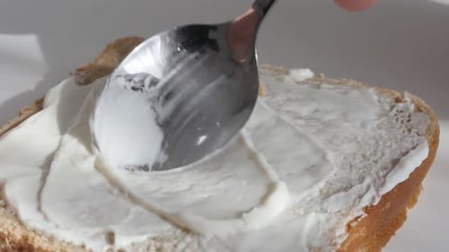Spreading Cream Cheese on Bread with Spoon