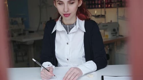 Fashion Designer Sketching Clothing Design in Studio