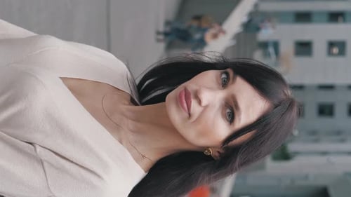 Vertikales Videoporträt einer selbstbewussten jungen Geschäftsfrau, die in der urbanen Stadt in die Kamera blickt