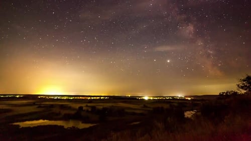 Starry Night in Mountains Time Lapse. Milky Way Galaxy Stars Moving Over Countryside Traffic. Night