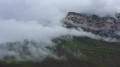Flug in den Wolken über dem Felsen