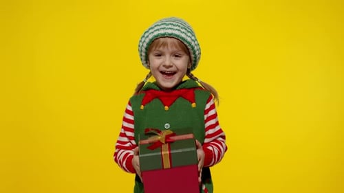 Joyful Child Receives Christmas Gift in Elf Costume