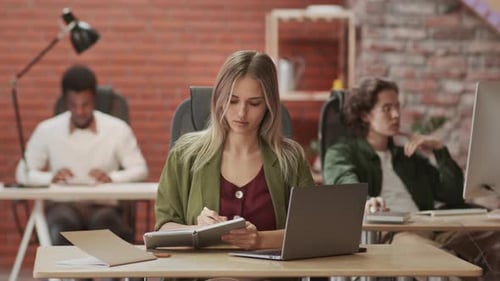 Empresária caucasiana sentada na mesa e trabalhando