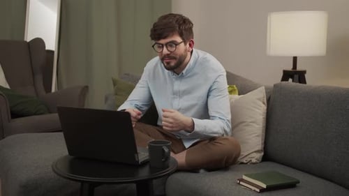 Man on Video Call From Gray Couch