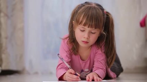 Girl Drawing with Pen on Floor at Home
