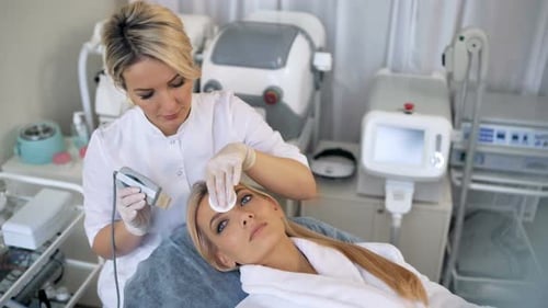 Cosmetologist Performs Facial Procedure on Lying Woman