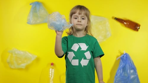 Niña activista con celofán y paquetes de papel. Reduzca la contaminación por plástico. Proteja el medio ambiente