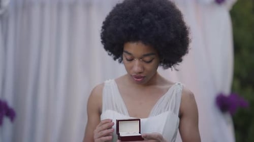 Woman Looks at Wedding Rings in Garden