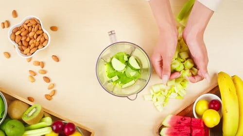Geschnittenes grünes Sellerie in den Mixer mit Äpfeln geben Nahaufnahme