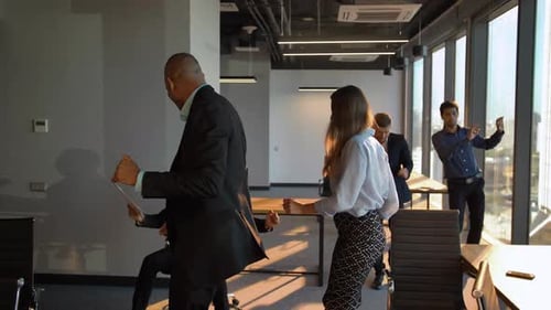 Geschäftsleute tanzen fröhlich im Büro vor der Kamera