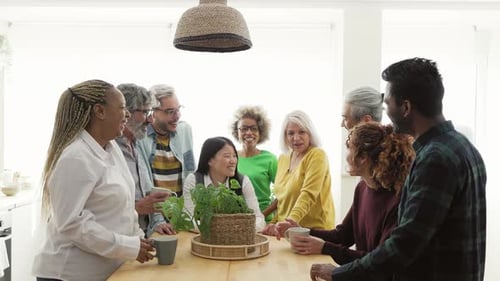 Happy Diverse Group Chatting Around Kitchen Table