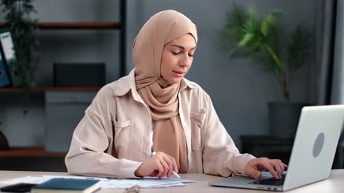 Woman Working on Laptop at Desk Indoors
