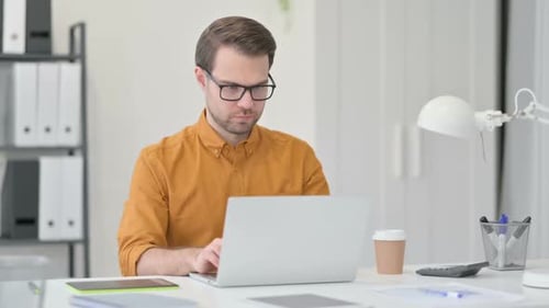 Junger Mann schließt Laptop und geht weg