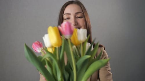 Happy Woman Smelling Bouquet of Colorful Tulips