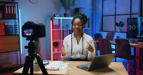 Una mánager afroamericana con blusa blanca aplaude después de terminar de grabar un nuevo vídeo