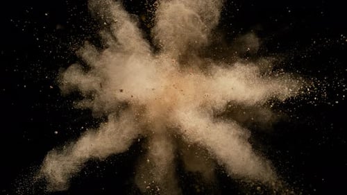 Bunte Pulver/Partikel fliegen, nachdem sie vor schwarzem Hintergrund explodiert wurden. Zeitlupe.