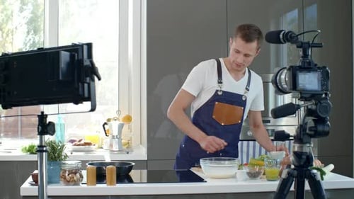 Man Cooking and Pouring Oil in Modern Kitchen