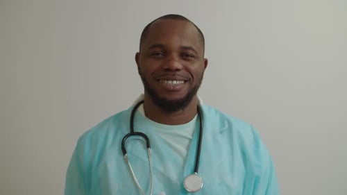Portrait of Cheerful Positive African American Man Doctor in Lab Coat Smiling at Hospital