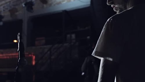 Male Performer Standing Near a Microphone on Stage